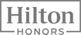 This image shows the logo for Hilton Honors, the loyalty program of Hilton Hotels. The text "Hilton" is above "HONORS" within a rectangular frame.
